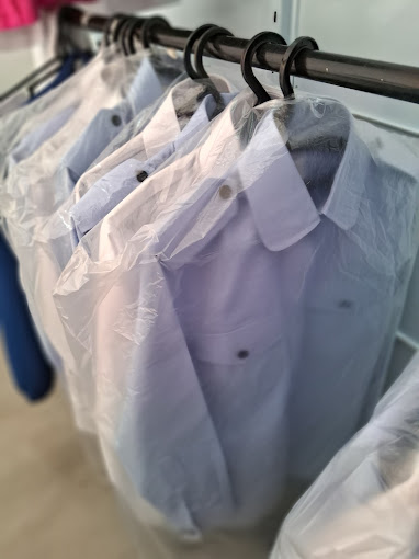 Camisas impecavelmente lavadas e passadas, penduradas em cabides com embalagem protetora